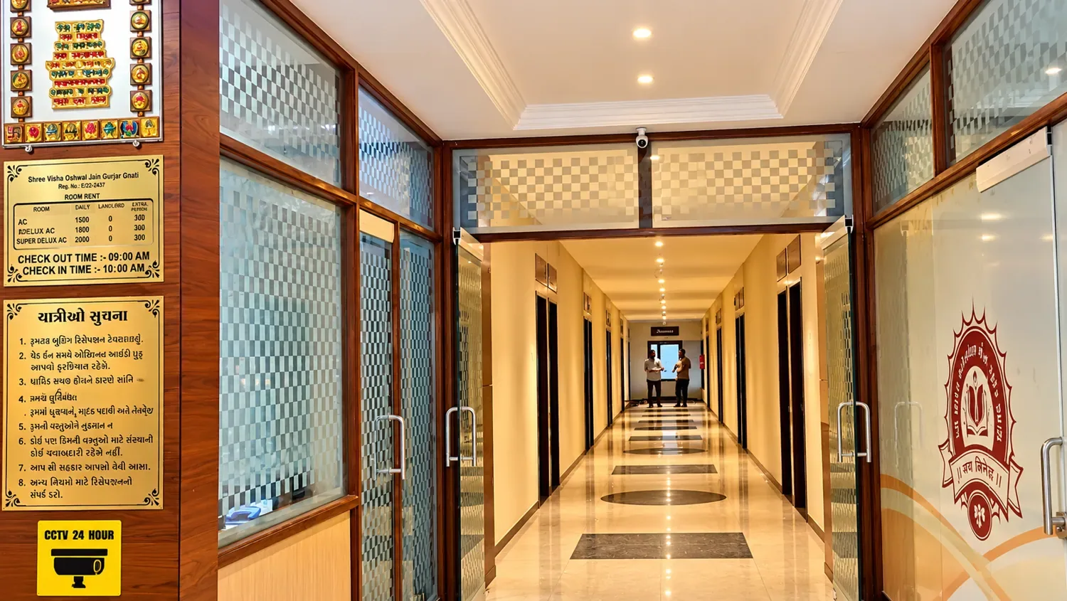 Guesthouse corridor with glass partitions and tariff board